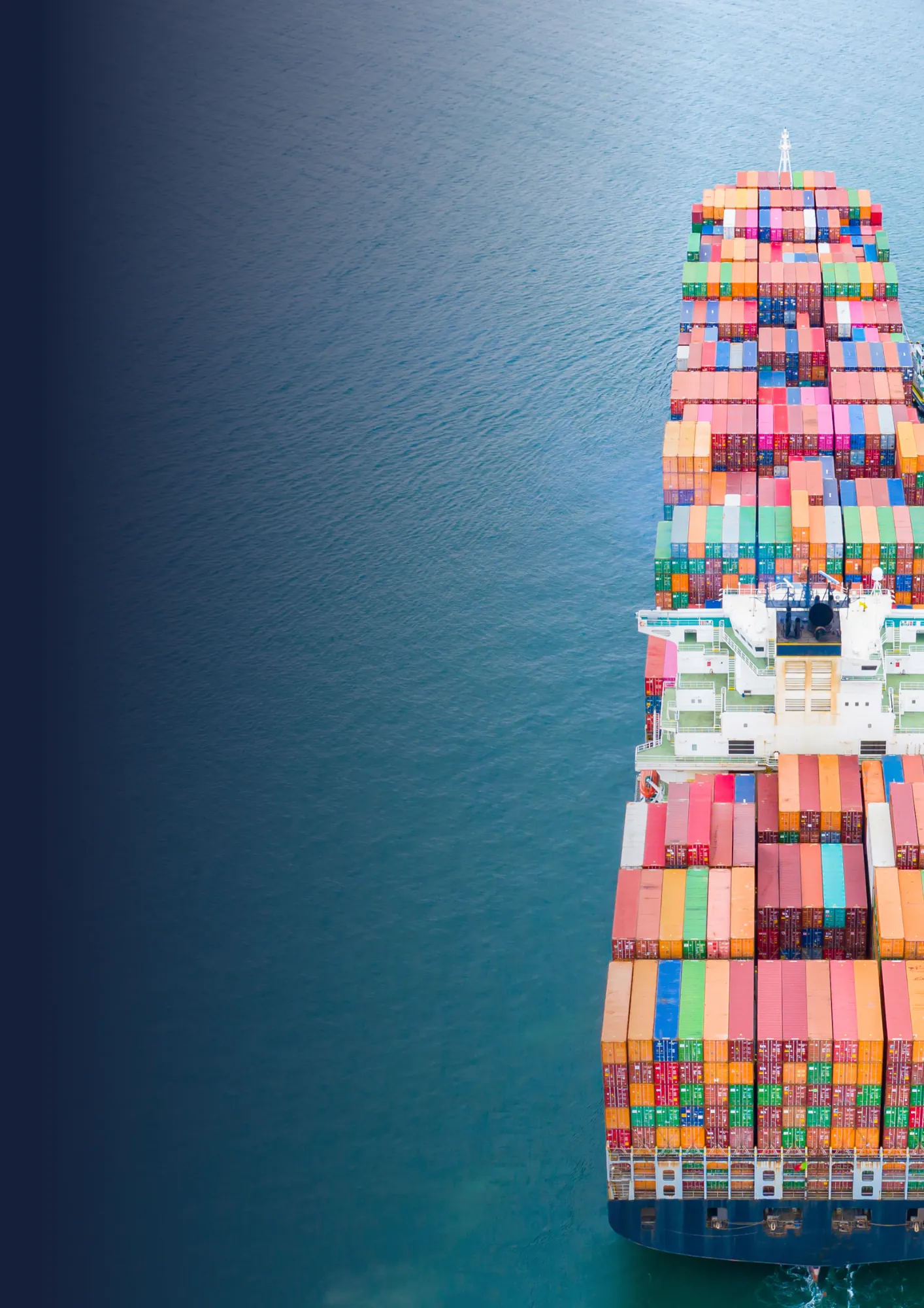 Overhead view of a ship carrying rows of colourful shipping containers.